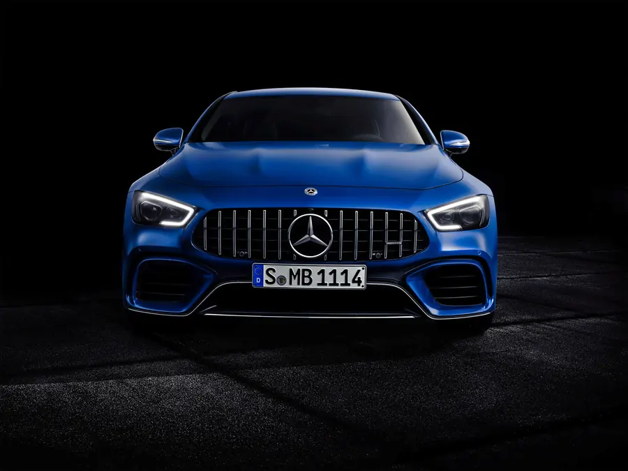 Quitar rayones de carro: Mercedes-AMG GT de cuatro puertas azul en fondo negro