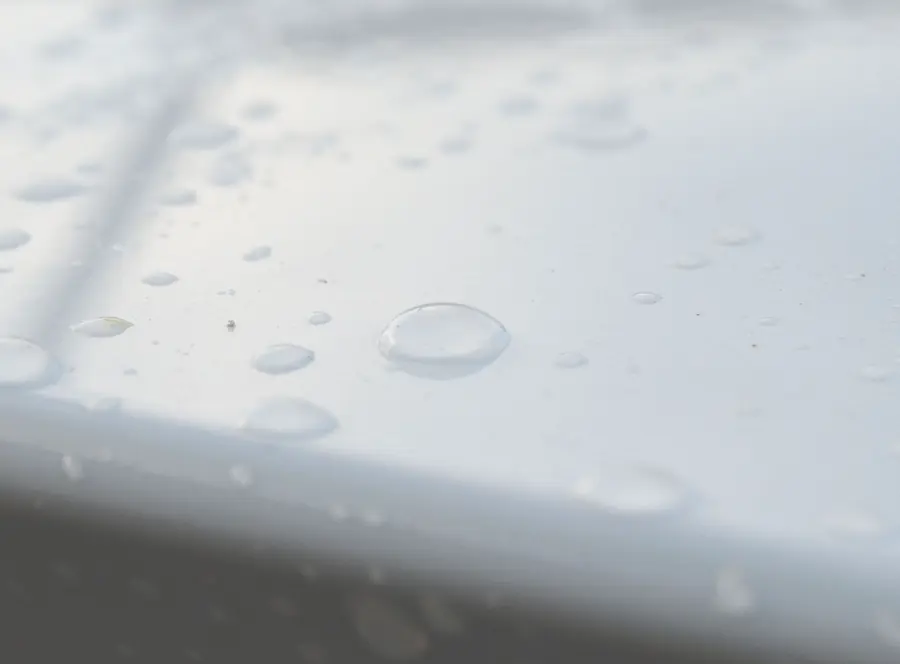 Auto lavado express: Gota de agua sobre cofre blanco con protección