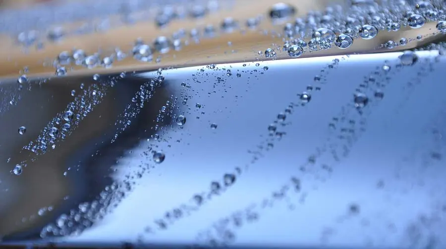 Polish para auto: Gotas de agua sobre cofre azul recién encerado