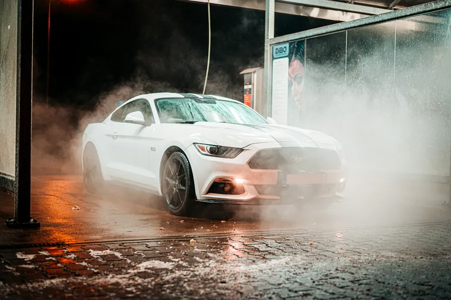 Autolavado cerca de mi: Auto blanco en lavado express con agua a presión y vapor