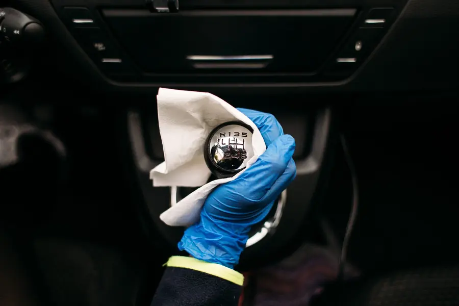 Ozono para auto: Mano enguantada limpiando la palanca de cambios