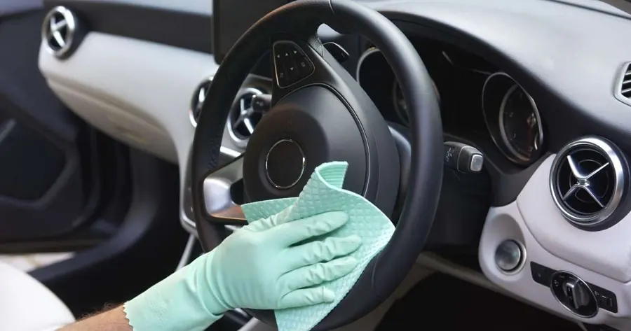 Lavado de interiores de autos: Limpieza de volante con guante y paño